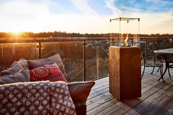 Foto des neocube-o auf einem Balkon, zusammen mit Gartenmöbeln. Im Hintergrund ist eine Wiese, sowie ein Wald.